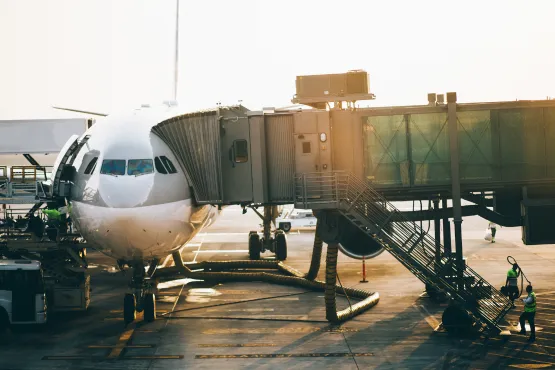 Un avion stationne au terminal relié à une passerelle vitrée