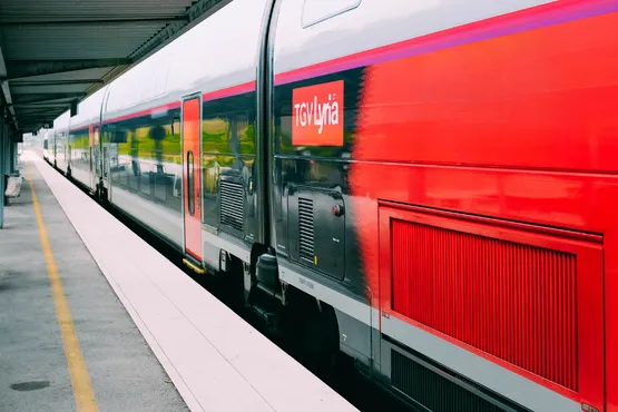 Un train rouge attend ses voyageurs le long du quai